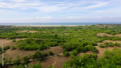 Sand Dunes of Paoay, Ilocos norte, Philippines. Landscape with tropical trees and the ocean in the distance, aerial view. 