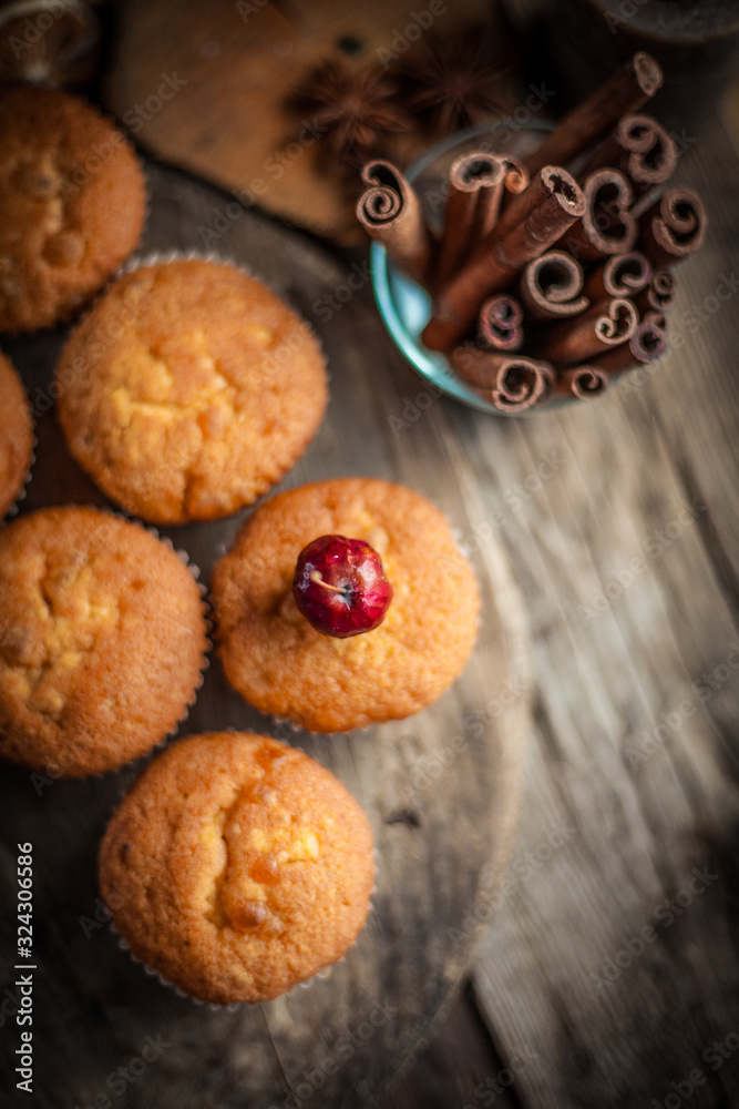 Muffin with a cherry on top. Beautiful cupcake on a wooden background in rustic style. Cooking, dessert. Muffins close-up, homemade cake. Muffin with a cherry on top. Beautiful cupcake on a wooden background in rustic style. Cooking, dessert. Muffins close-up, homemade cake.