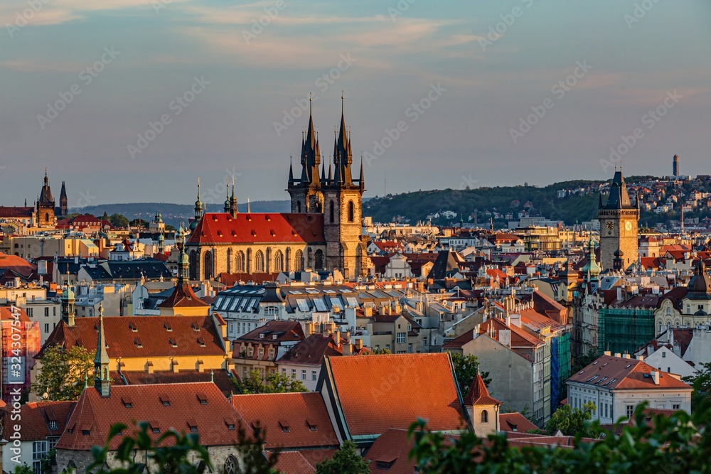 Prague / Czech Republic - May 23 2019: Scenic view of the cityscape, the Tyn Cathedral and Old Town Hall Tower on a spring sunny evening. Blue and pink sky.