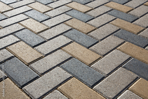 Background - colorful cobblestone pavement of the new paving stones. Diminishing perspective. Backlight.