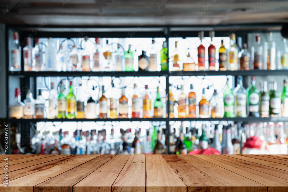 image of wooden table in front of abstract blurred background of bar lights.Blur bar or cafe restaurant with abstract bokeh light background.