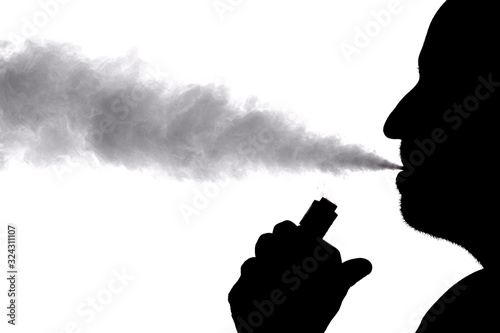 Man with electronic cigarette and smoke vapping with white background and silhouette shape photo