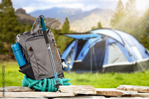Backpack on stones and blurred blue tent.Spring trip time. 
