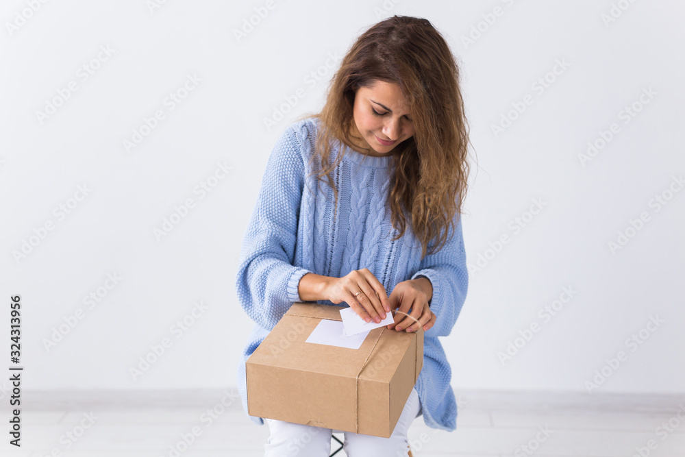 Online shopping, delivery and fashion concept - Woman sitting at home opening online clothing purchase Online shopping, delivery and fashion concept - Woman sitting at home opening online clothing purchase