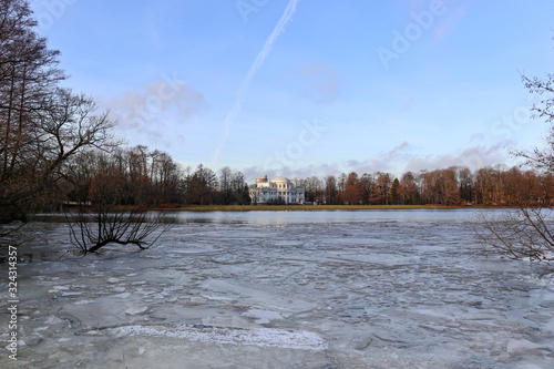 Winter view of Nevka River near Yelagin Island in St.Petersburg, Russia. Landscape with cold water, ice, trees and a building facade. photo