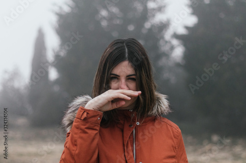 young woman blowing her nose