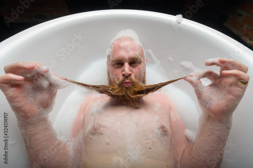 Obraz na plátne A bald man is fooling around in the foam bath