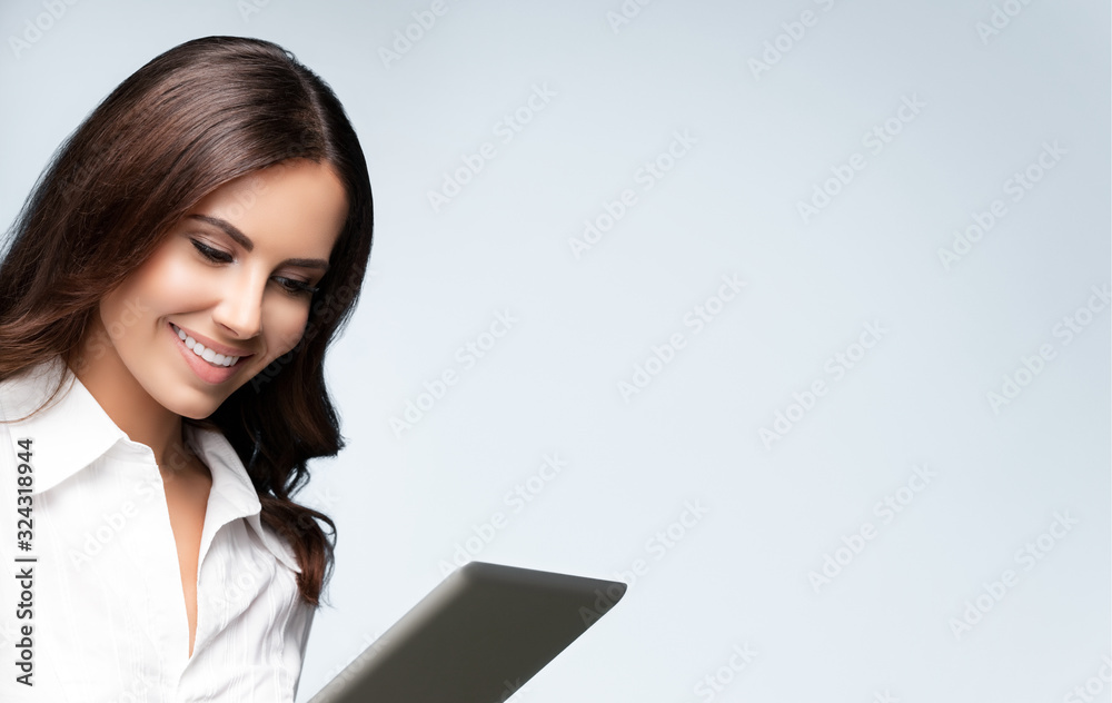 businesswoman using no-name tablet pc, over grey businesswoman using no-name tablet pc, over grey