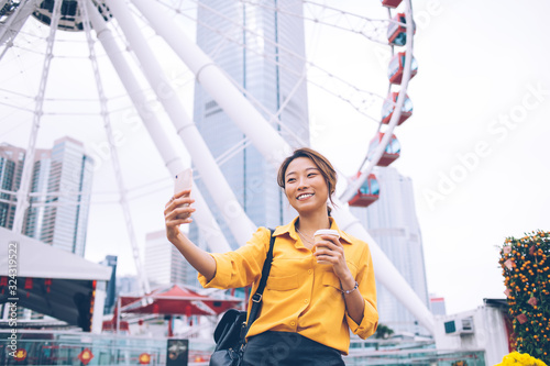 Valokuva Happy young Asian woman taking photo in amusement park