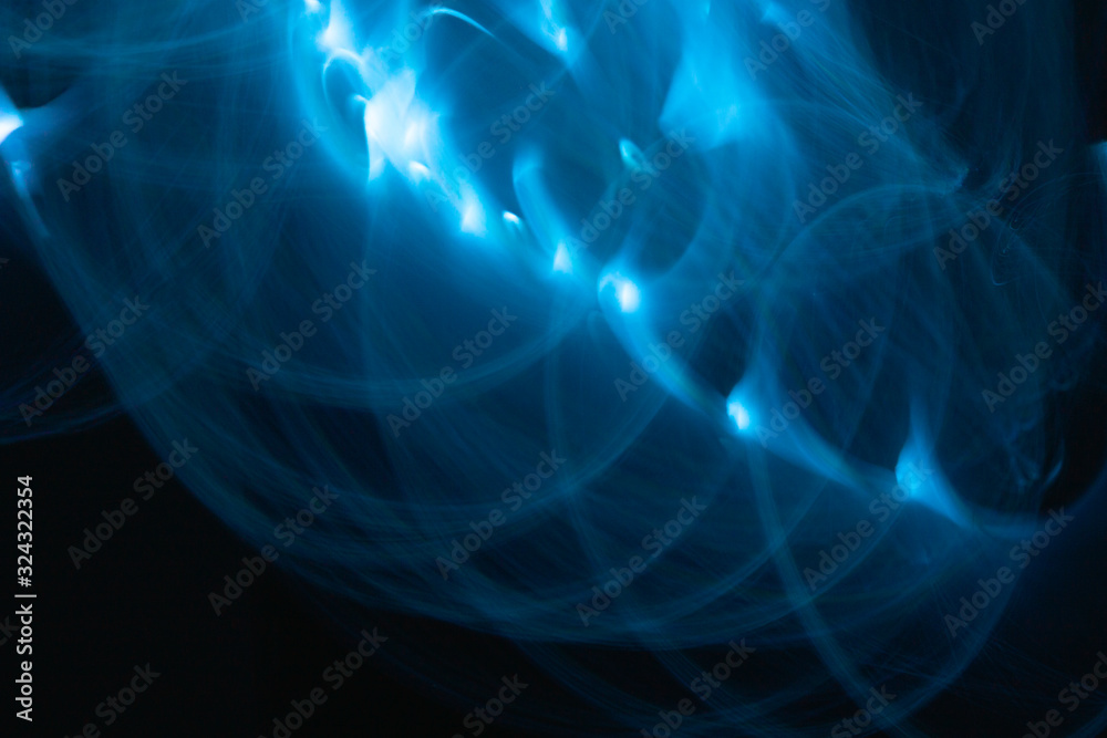 Neon blue light painting, long exposure photography, loop and swirl pattern against a black background. Abstract of blurred lighting equipment. Neon blue light painting, long exposure photography, loop and swirl pattern against a black background. Abstract of blurred lighting equipment.