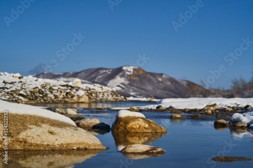 Nature landscape with mountains, snowy cliffs and river.