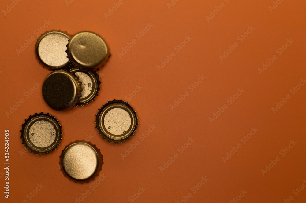 group of seven bottle caps on orange background group of seven bottle caps on orange background