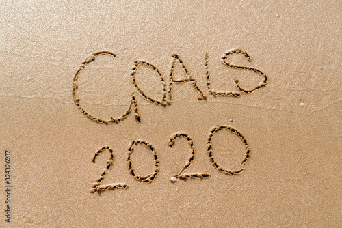 foamy sea water and Inscription Goals 2020 on the sandy beach