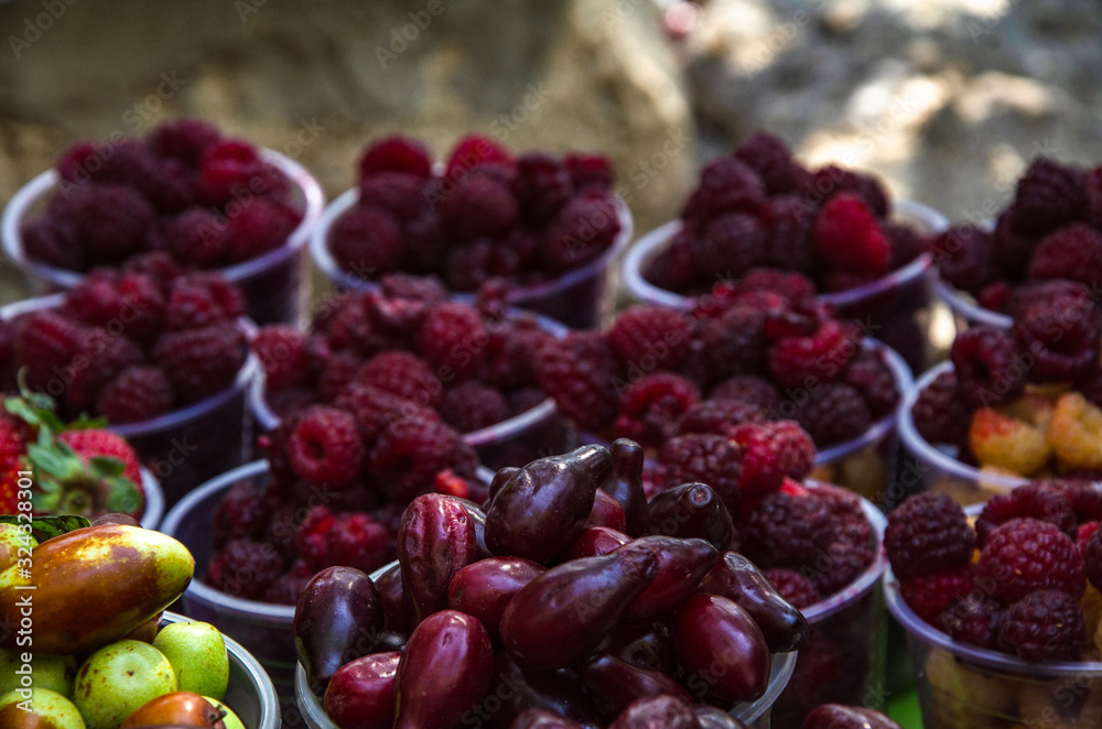 Ripe fruits in glasses for street sale. Jujube, Red and white raspberries, figs, nuts. Travel and adventure. Ripe fruits in glasses for street sale. Jujube, Red and white raspberries, figs, nuts. Travel and adventure.