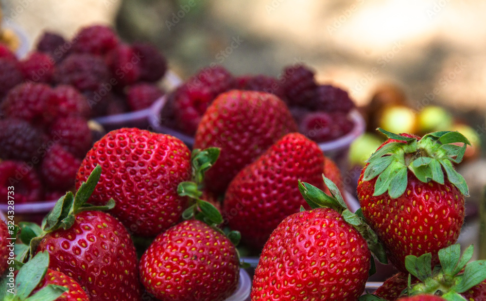 Ripe fruits in glasses for street sale. Red and white raspberries, strawberries figs, nuts. Travel and adventure. Ripe fruits in glasses for street sale. Red and white raspberries, strawberries figs, nuts. Travel and adventure.