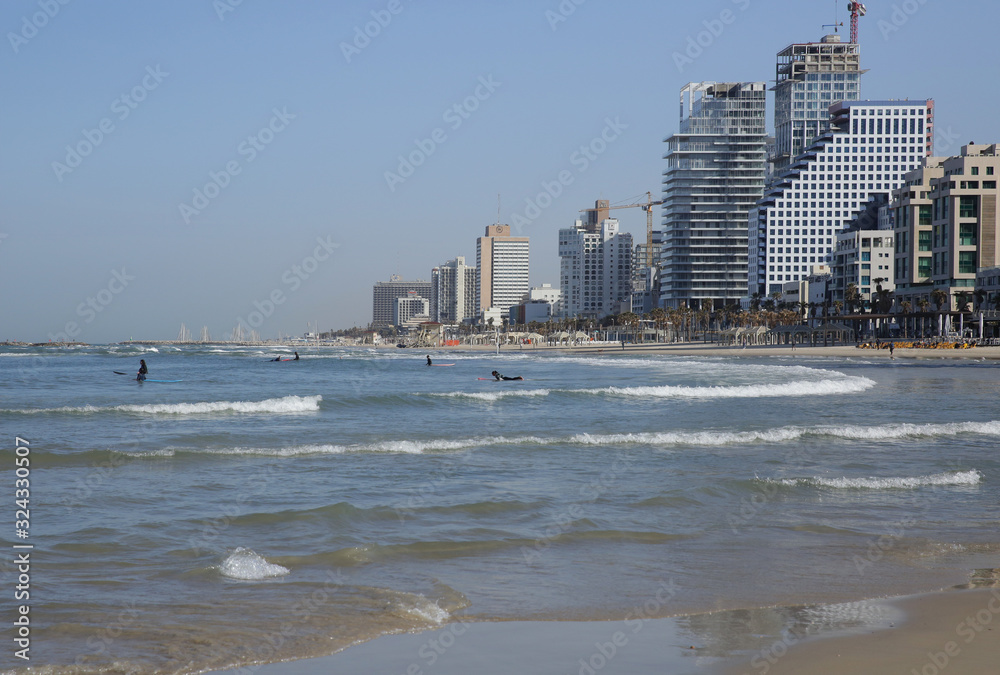  view of the Tel Aviv skyline from the sea with surfers