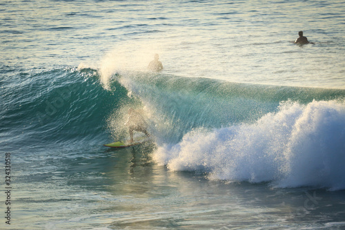 Surfer on Ocean Wave Getting Barreled at Sunset © nvphoto