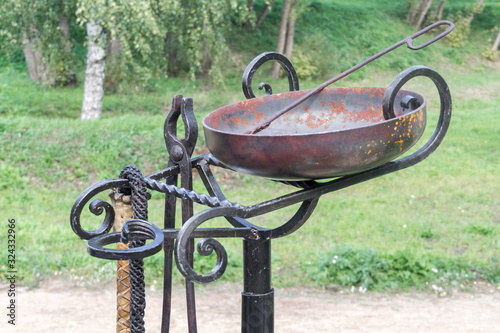 Medieval torture instruments. On black metal stand hangs leather whip ...
