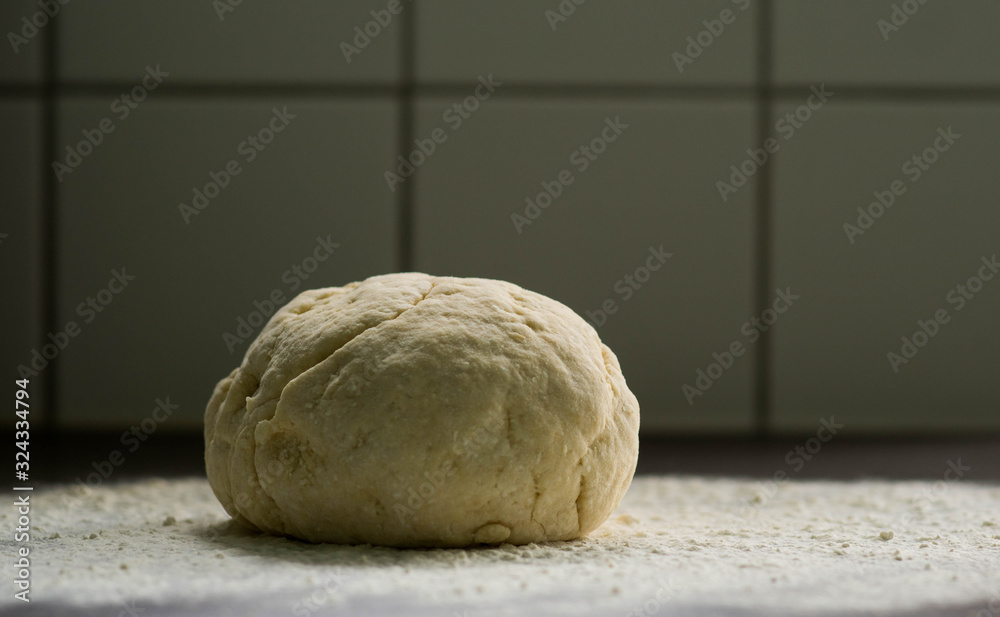 Pastry, bread making - baking healthy, sustainable and organic food. Piece of handmade pastry on kitchen table covered with flour Pastry, bread making - baking healthy, sustainable and organic food. Piece of handmade pastry on kitchen table covered with flour