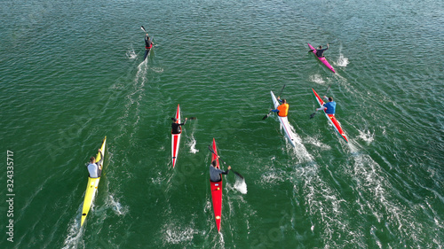 Canvas Print Aerial drone photo of athletes competing in canoe race in tropical lake with eme