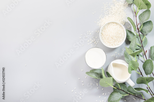 Vegan rice plant based milk in bottles, closeup, gray background. Non dairy alternative milk. Healthy vegetarian food and drink concept. Copy space, top view photo