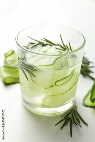 Glass with cucumber water on white background, close up