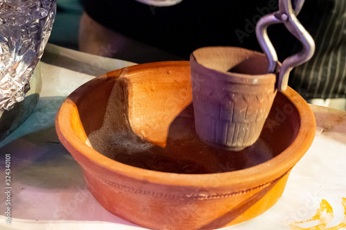 Indian street food vendor making tandoori masala chai tea by boiling in a hot clay pot in brass pot to boil the tea photo