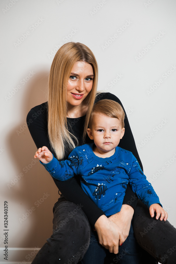 Blonde long hair hot glamour mother playing with her baby boy child at home spending quality family values time Blonde long hair hot glamour mother playing with her baby boy child at home spending quality family values time