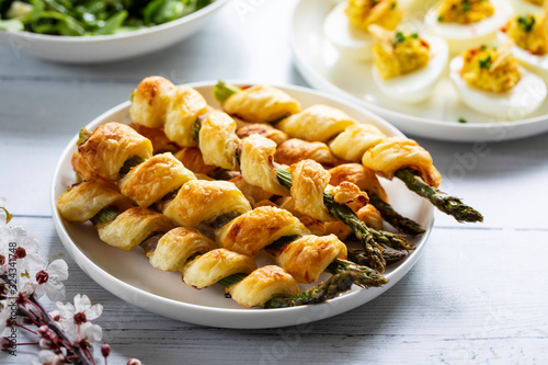 Fotografi Aspargus wrapped in puff pastry and devilled eggs canapes on the white plate