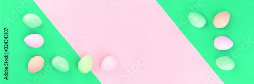 Happy Easter banner of tender dyed pastel easter eggs lined on pink and green background in flat lay with copy space