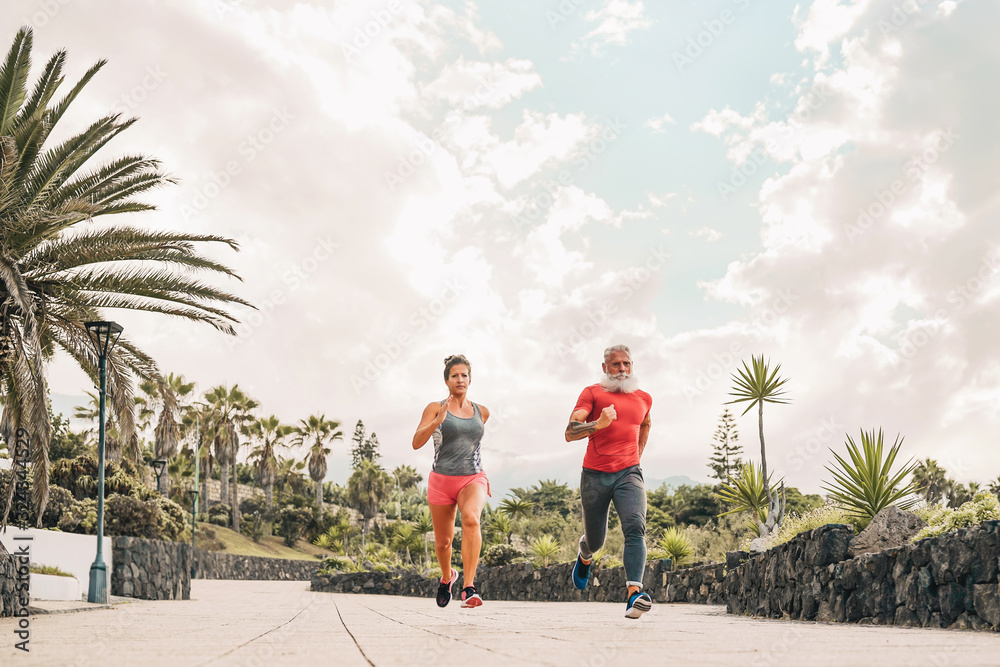 Obraz premium Couple doing running training session outdoor - Sporty people workout sprint exercises - Health activity and lifestyle sport concept