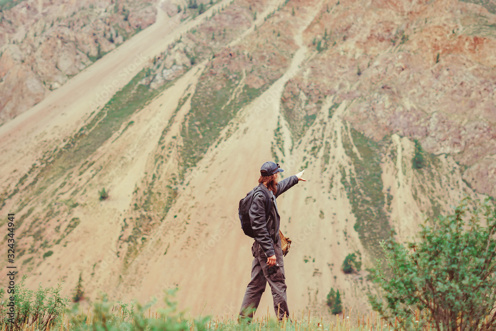 Obraz premium guy with a backpack near the mountains