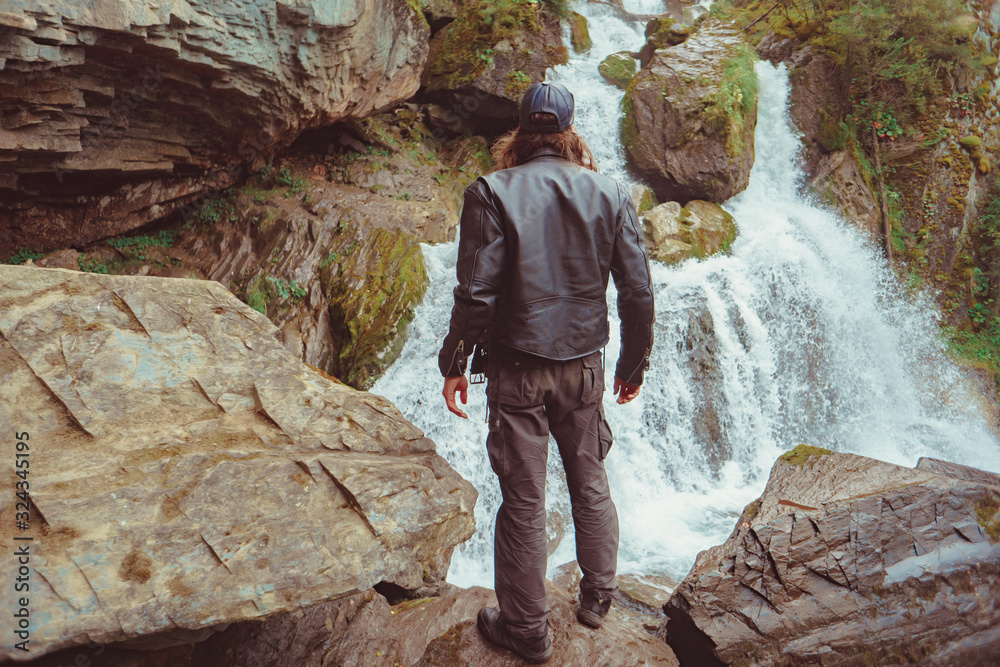 the guy is standing at the waterfall the guy is standing at the waterfall