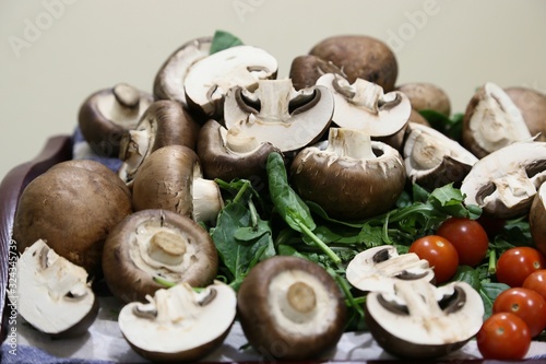 Still life from products: mushrooms, spinach, tomatoes small and large, onions side view