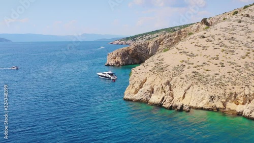 Luxury lifestyle, Summer vacation on the yacht visiting cliffed coast of Croatian island Krk. Aerial shot reveals hidden beach Golden Bay photo