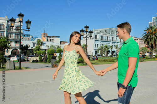 Romantic happy woman and man dancing on street. Young couple walking outdoors near sea port, Batumi Georgia.