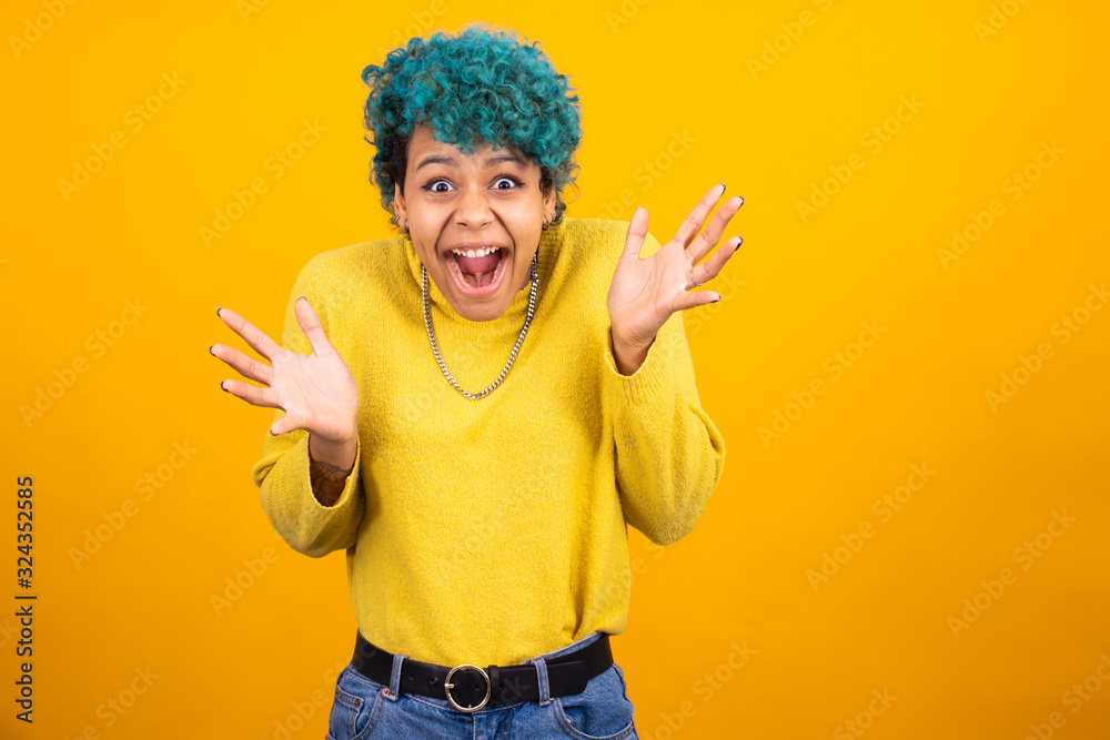 young brunette woman with trendy blue hair isolated on color background