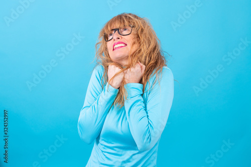 adult or senior woman isolated on blue background © carballo