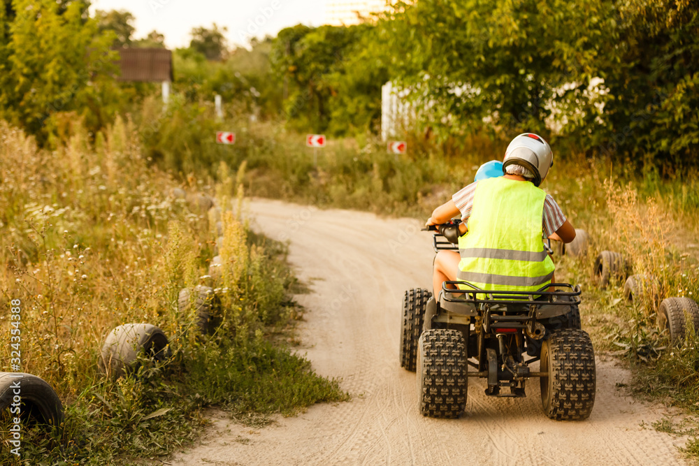 little boy with instructor on a quad bike little boy with instructor on a quad bike