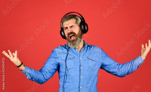 bearded man hipster in headset. Listening to music. Time to relax. brutal hipster wear earphone. singing and dancing. Enjoying his favorite music. Man listening music with his headphones photo