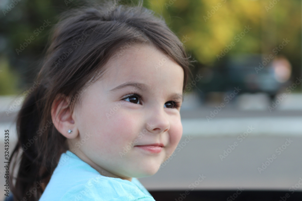 Two amazing girls ride in one big toy car on city street asphalt. Outdoor driving in a summer attraction for children Two amazing girls ride in one big toy car on city street asphalt. Outdoor driving in a summer attraction for children