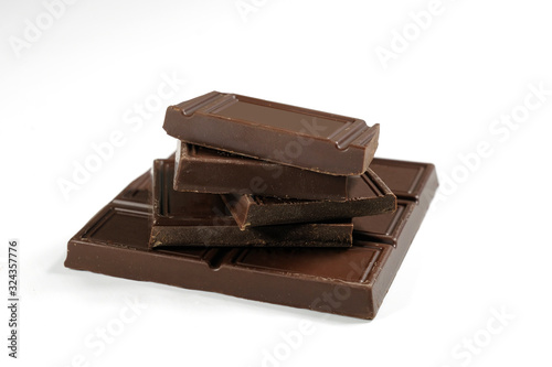 Broken chocolate bar is isolated on a white background. Close-up.