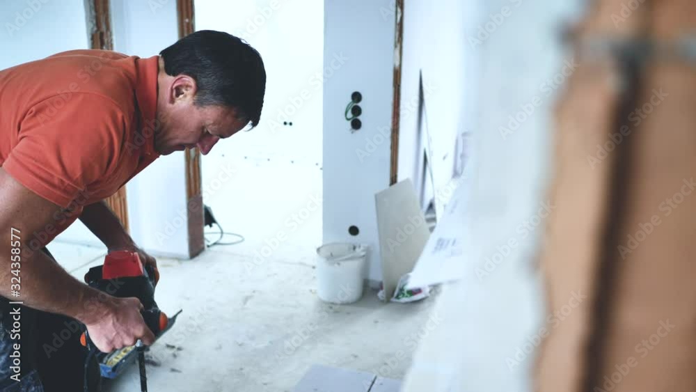 Handwerker schneidet grosse fliesen mit Fliesenschneider in einem neubau haus 4k Video in zeitlupe Handwerker schneidet grosse fliesen mit Fliesenschneider in einem neubau haus 4k Video in zeitlupe