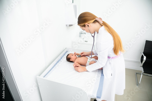 medicine, healthcare and pediatrics concept - female pediatrician or neuropathist doctor or nurse checking baby patient's at clinic or hospital photo