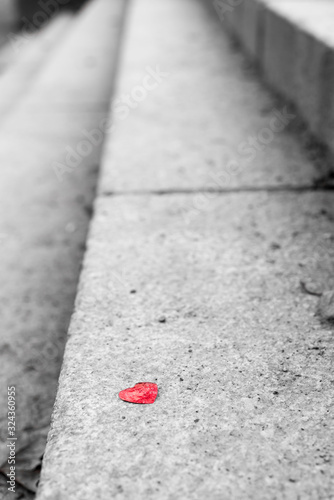 A red heart lies on the gray stairs
