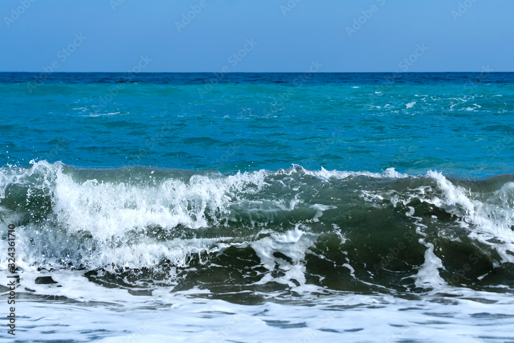 Wavy aquamarine sea and blue sky