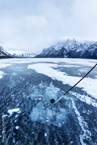 Photography Playing Ice Hockey on Frozen Lake Minnewanka in Banff, Alberta, Canada