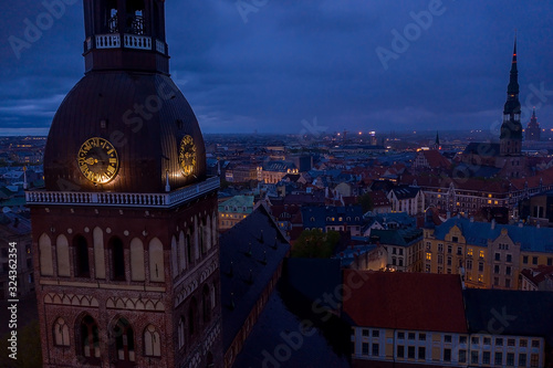 Beautiful aerial panorama of Riga center near Vansu bridge over Daugava river during cloudy evening. View of illuminated Riga city, capital of Latvia.