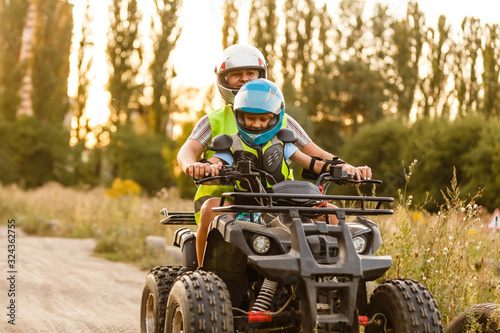 little boy with instructor on a quad bike photo