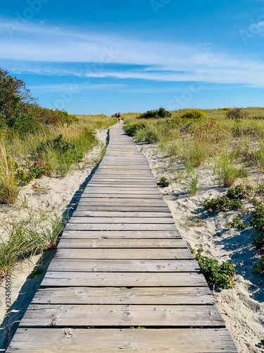 Wooden pathway through sandy dunes at the beach in the summer